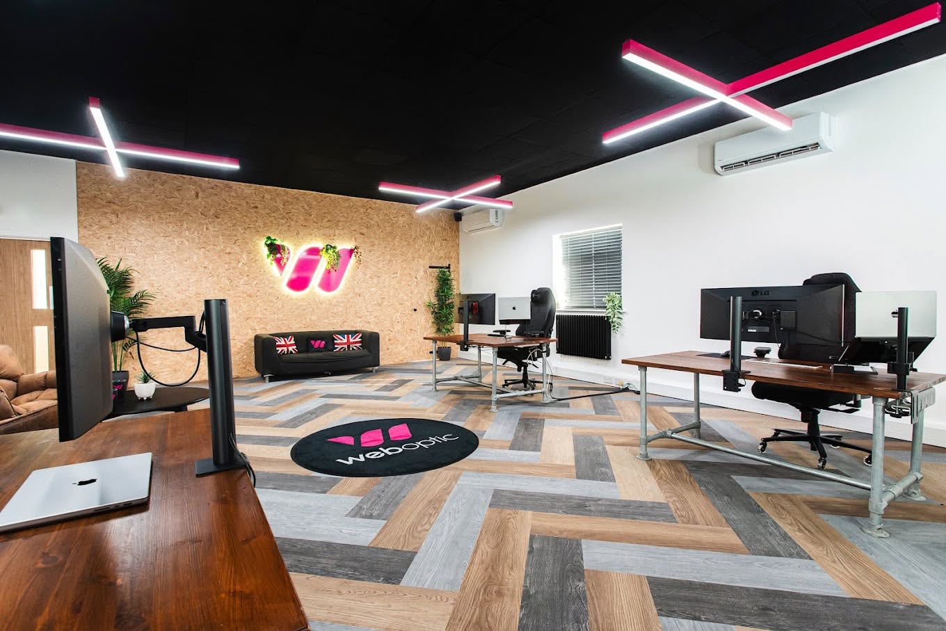 Desks, workstations and pink lighting inside Web Optic’s Staffordshire studio